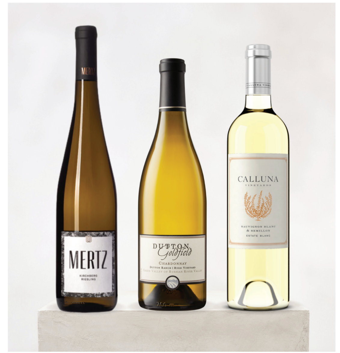 Three bottles of white wine with labels on a light gray background